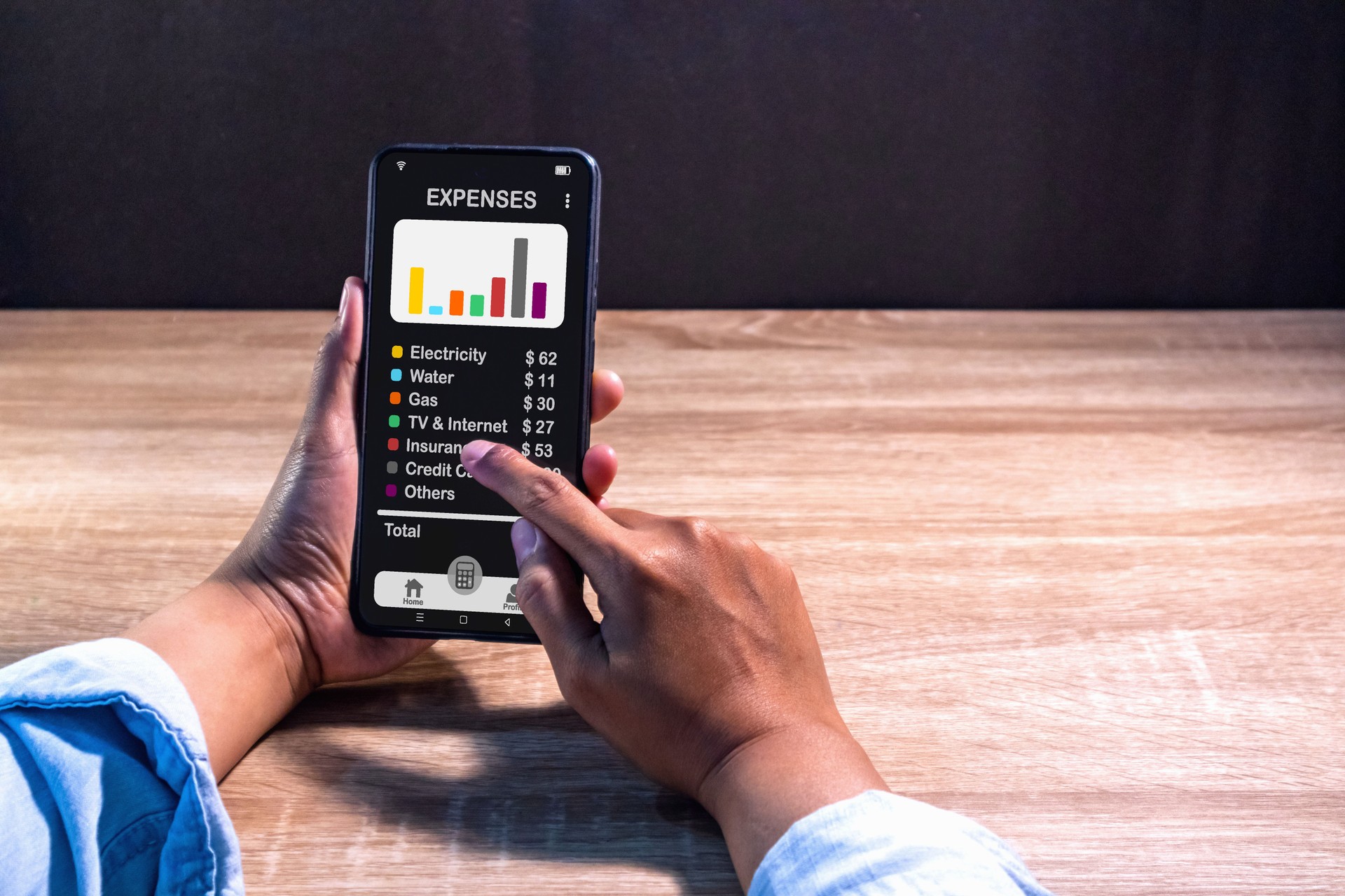 Woman using a smartphone app to calculate the monthly bills or household expenses